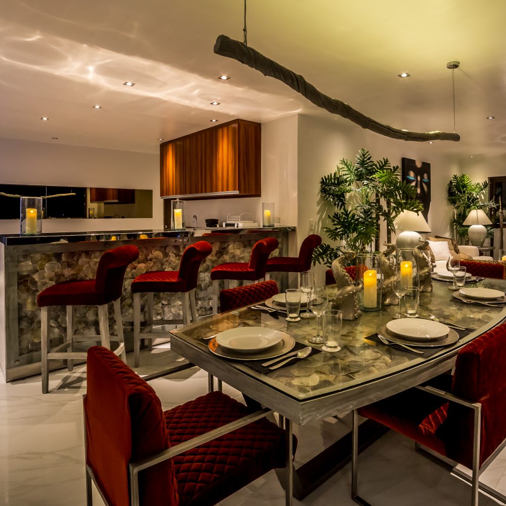 The dining area and kitchen at night will entice you to whip up and enjoy dinner.